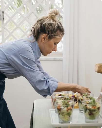 Profissional preparando porções individuais para evento corporativo